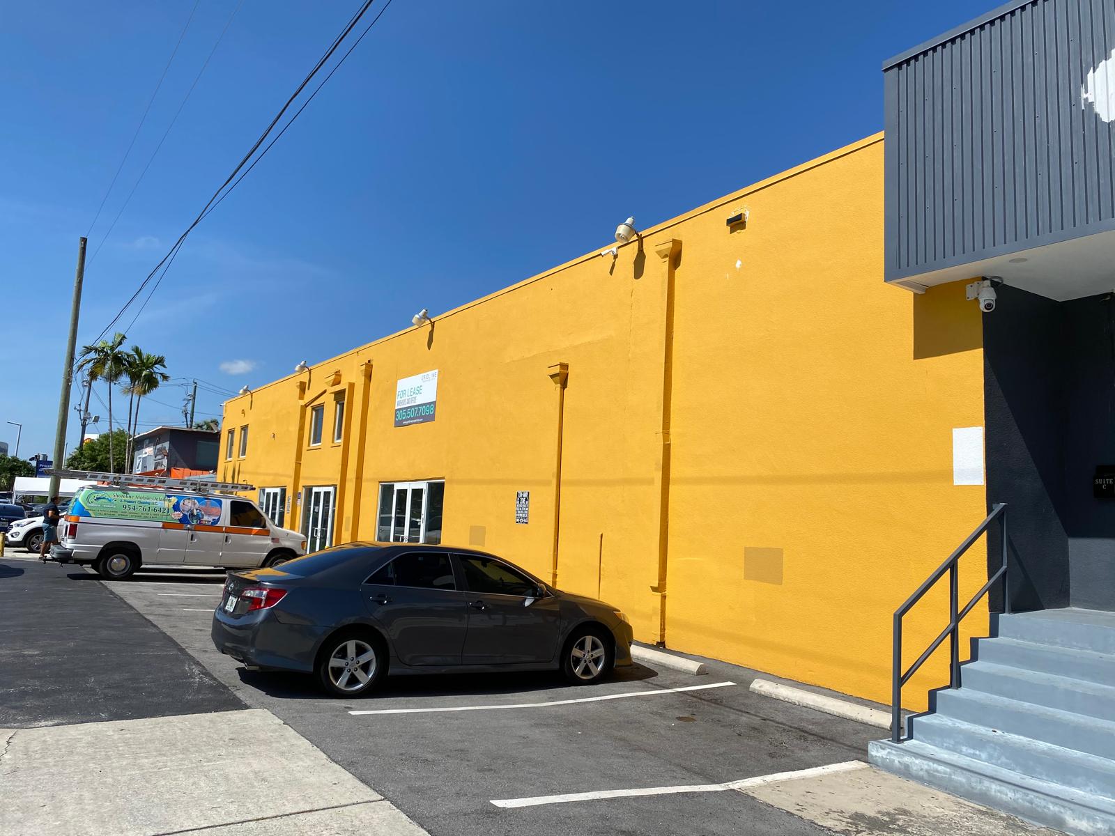 Yellow exterior commercial warehouse painting on a large industrial building in Miami Florida