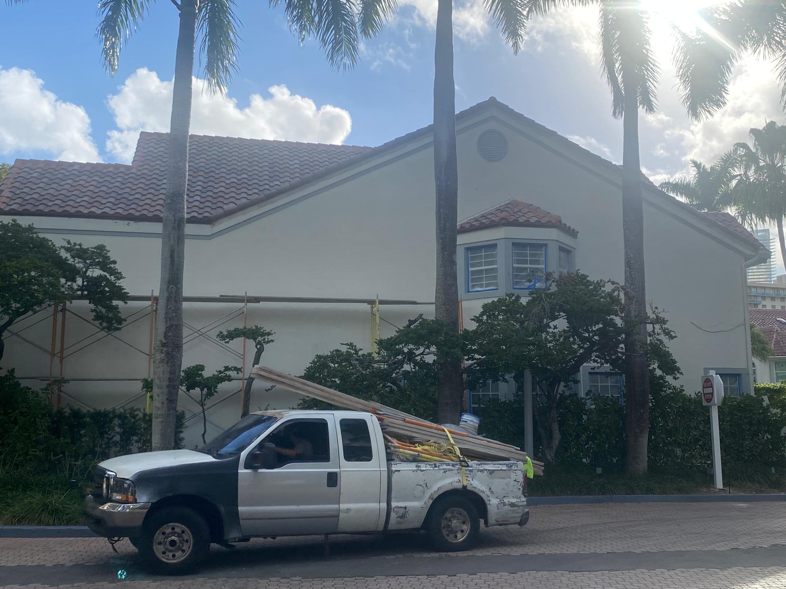 Exterior stucco painting preparation and window masking on a Miami residential property